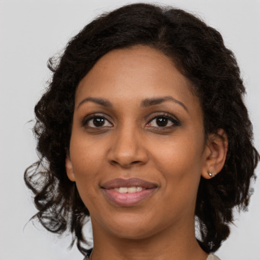 Joyful black young-adult female with medium  brown hair and brown eyes