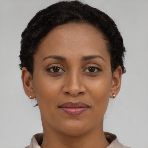 Joyful black young-adult female with short  brown hair and brown eyes