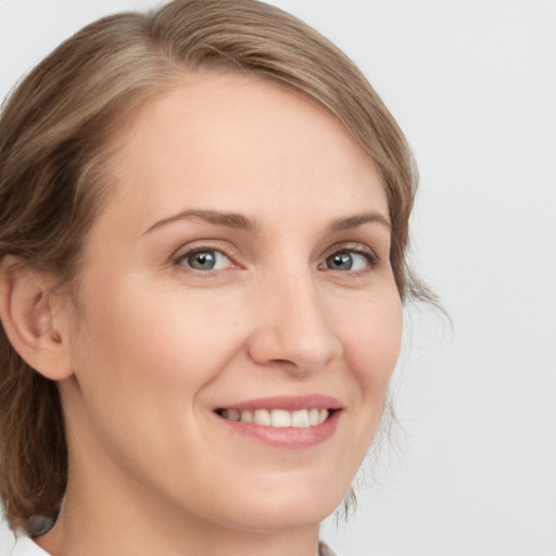 Joyful white young-adult female with medium  brown hair and green eyes