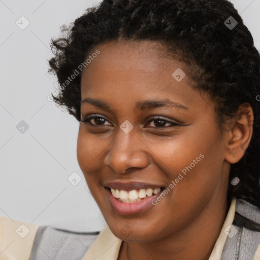 Joyful black young-adult female with medium  brown hair and brown eyes