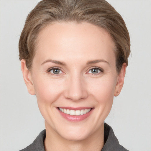 Joyful white adult female with short  brown hair and grey eyes