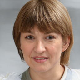 Joyful white adult female with medium  brown hair and grey eyes