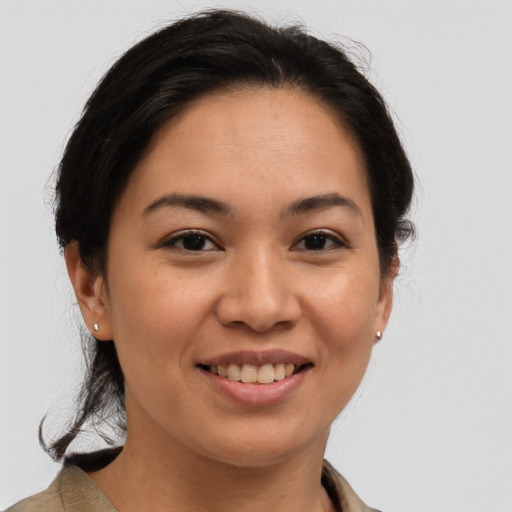Joyful latino young-adult female with medium  brown hair and brown eyes