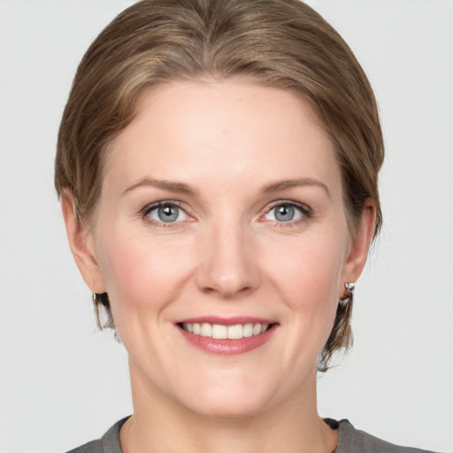 Joyful white young-adult female with medium  brown hair and grey eyes