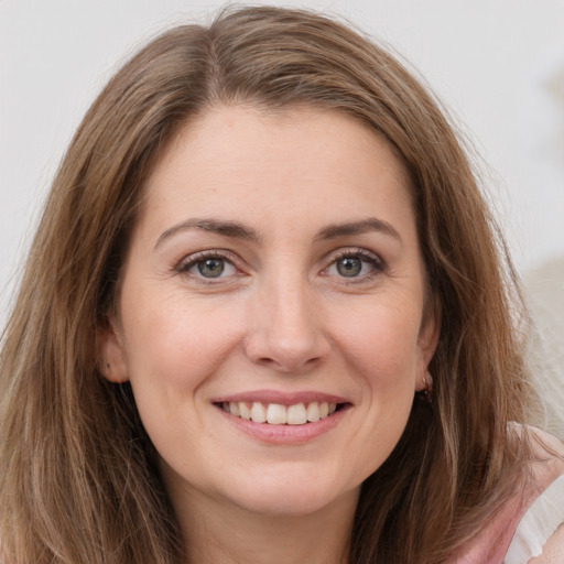 Joyful white young-adult female with long  brown hair and green eyes