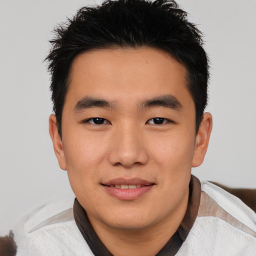 Joyful asian young-adult male with short  black hair and brown eyes