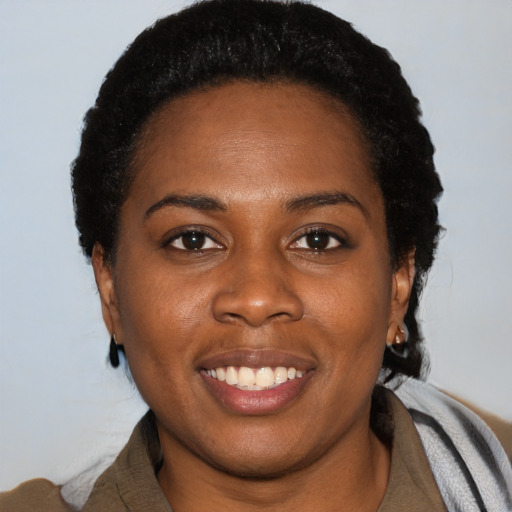 Joyful black young-adult female with short  black hair and brown eyes
