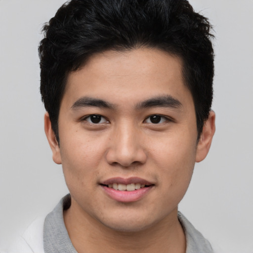Joyful asian young-adult male with short  black hair and brown eyes