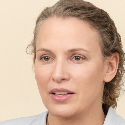 Joyful white adult female with medium  brown hair and grey eyes