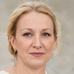 Joyful white adult female with medium  brown hair and blue eyes