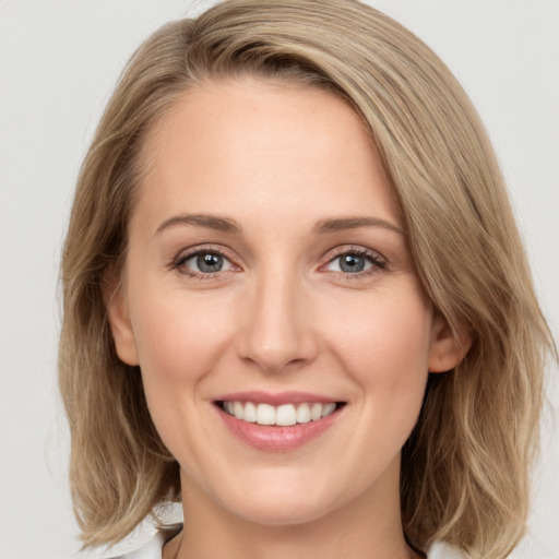 Joyful white young-adult female with medium  brown hair and green eyes