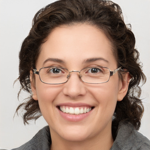 Joyful white adult female with medium  brown hair and green eyes