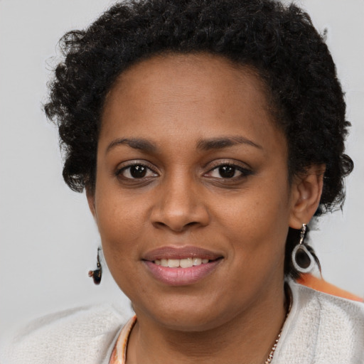 Joyful black young-adult female with short  brown hair and brown eyes