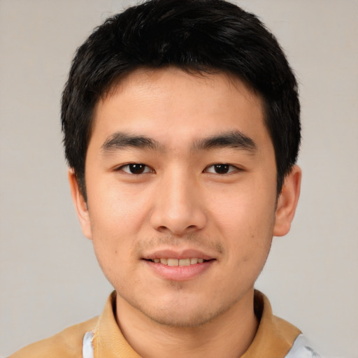 Joyful asian young-adult male with short  black hair and brown eyes
