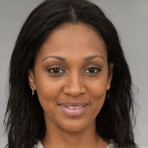 Joyful black young-adult female with long  brown hair and brown eyes