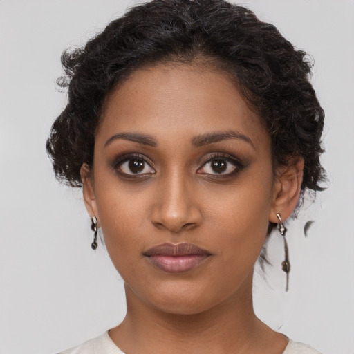 Joyful black young-adult female with short  brown hair and brown eyes