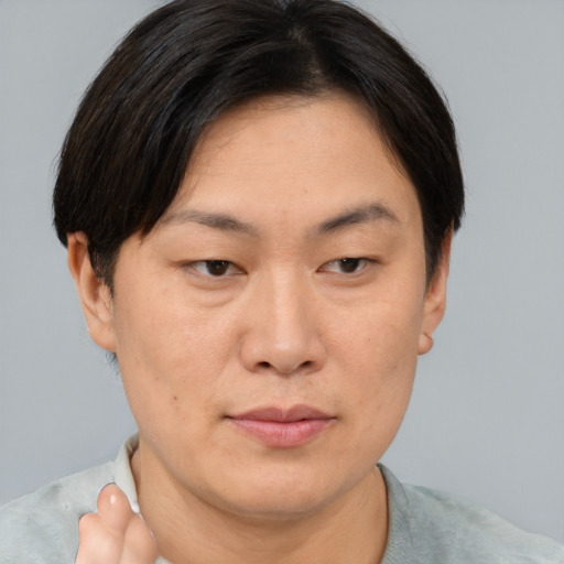 Joyful asian young-adult female with short  brown hair and brown eyes