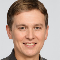 Joyful white adult male with short  brown hair and grey eyes