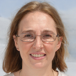 Joyful white adult female with medium  brown hair and blue eyes