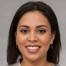 Joyful latino young-adult female with medium  brown hair and brown eyes