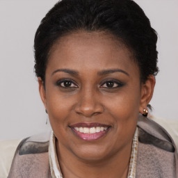 Joyful black young-adult female with short  brown hair and brown eyes