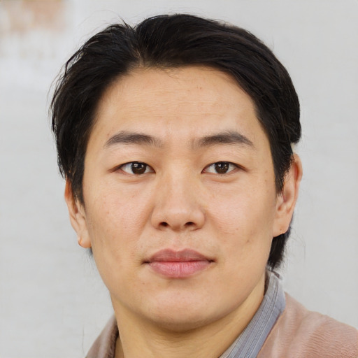 Joyful asian adult male with short  brown hair and brown eyes