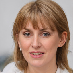 Joyful white adult female with medium  brown hair and blue eyes