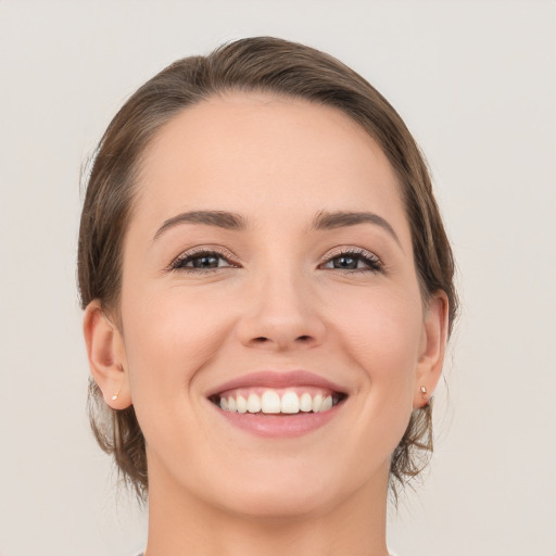 Joyful white young-adult female with medium  brown hair and grey eyes