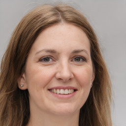 Joyful white adult female with long  brown hair and grey eyes