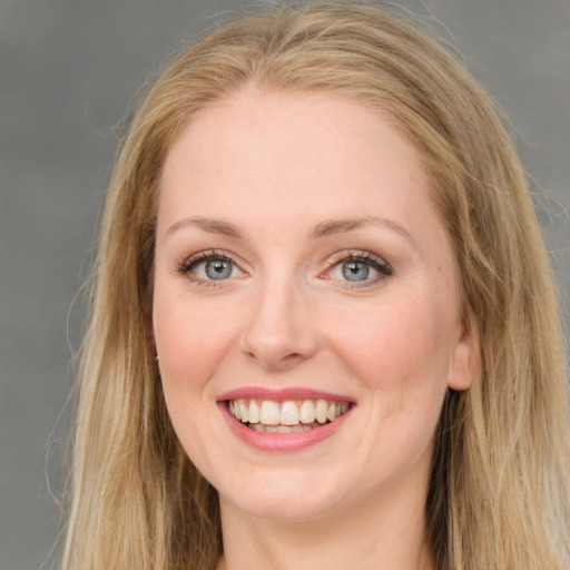 Joyful white young-adult female with long  brown hair and blue eyes