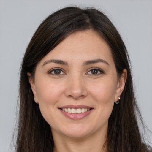 Joyful white young-adult female with long  brown hair and brown eyes