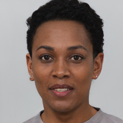 Joyful black young-adult female with short  black hair and brown eyes