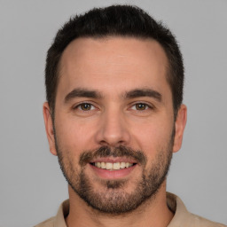 Joyful white young-adult male with short  brown hair and brown eyes