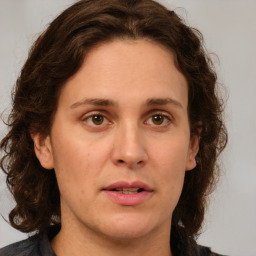 Joyful white adult female with medium  brown hair and green eyes