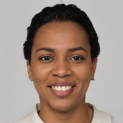 Joyful black young-adult female with short  black hair and brown eyes