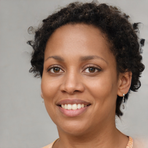 Joyful black young-adult female with short  brown hair and brown eyes