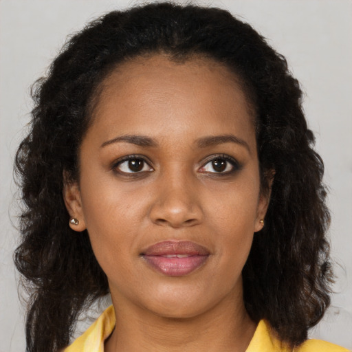 Joyful black young-adult female with long  brown hair and brown eyes