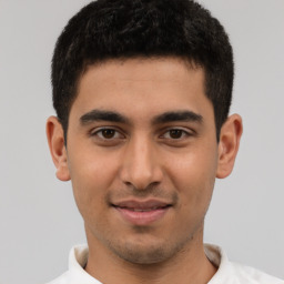 Joyful latino young-adult male with short  brown hair and brown eyes