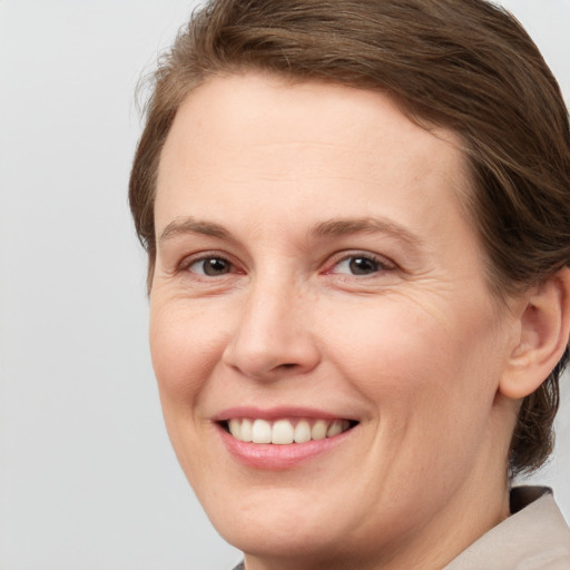 Joyful white young-adult female with medium  brown hair and grey eyes