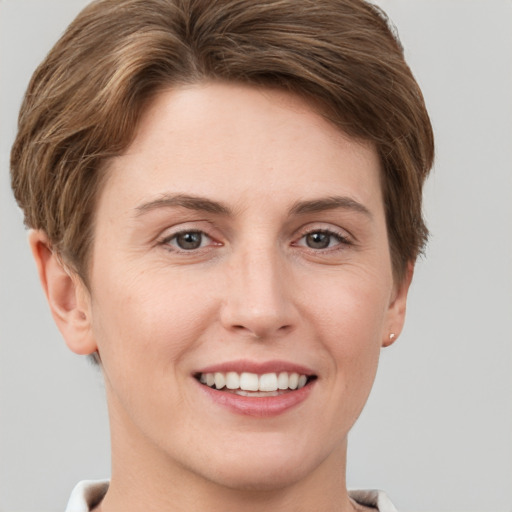 Joyful white young-adult female with short  brown hair and grey eyes