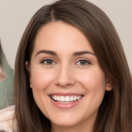 Joyful white young-adult female with long  brown hair and brown eyes