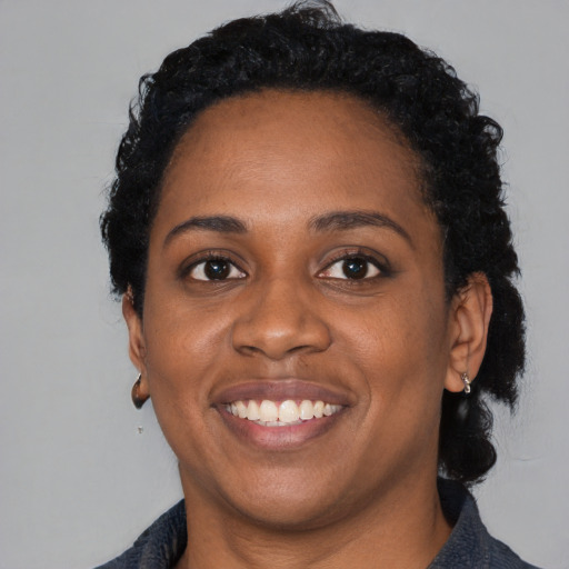 Joyful black young-adult female with medium  black hair and brown eyes