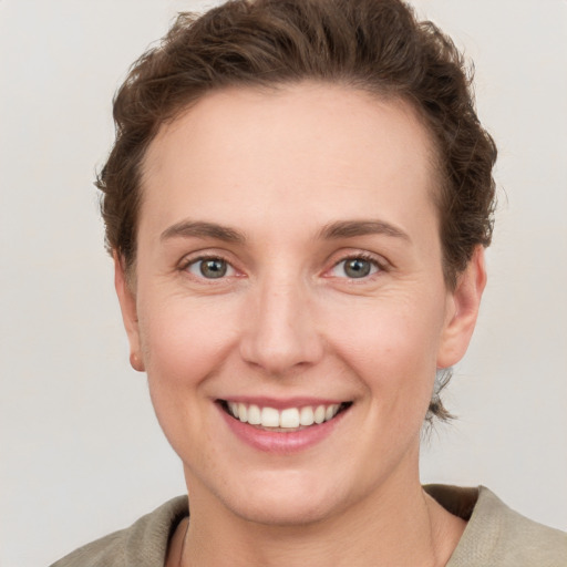 Joyful white young-adult female with short  brown hair and grey eyes