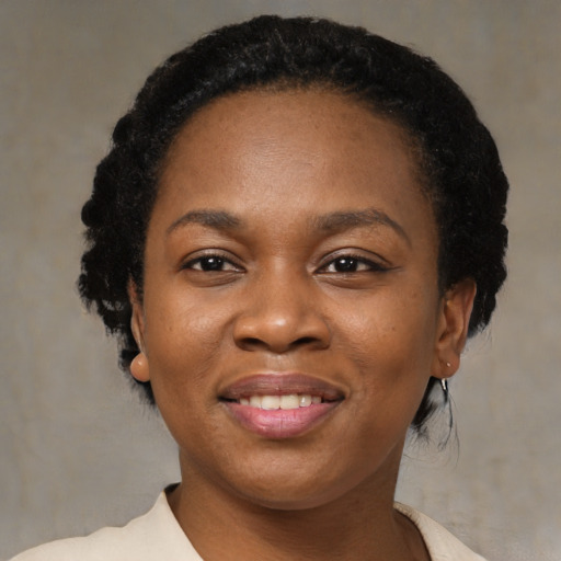 Joyful black young-adult female with short  black hair and brown eyes