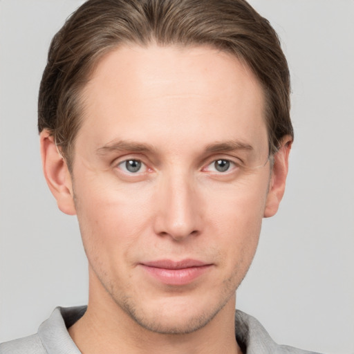 Joyful white young-adult male with short  brown hair and grey eyes