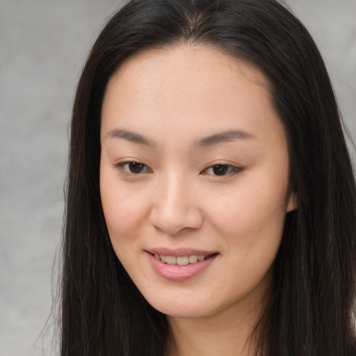 Joyful asian young-adult female with long  brown hair and brown eyes