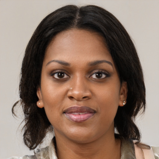 Joyful black young-adult female with medium  brown hair and brown eyes