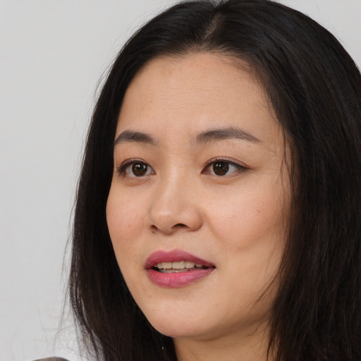 Joyful asian young-adult female with long  brown hair and brown eyes