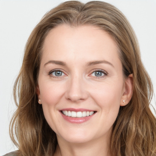 Joyful white young-adult female with long  brown hair and grey eyes