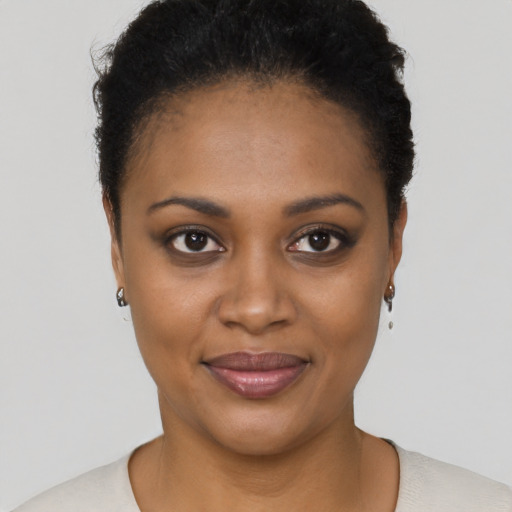 Joyful black young-adult female with short  black hair and brown eyes